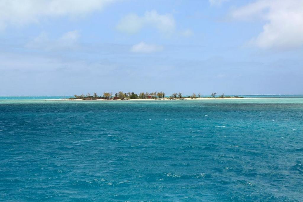 Cargados Carajos Shoals - the low atolls are barely visible in the day. The reef can be just seen as white water in the far distance © SW